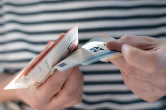 A euro banknote in a man's hand.
