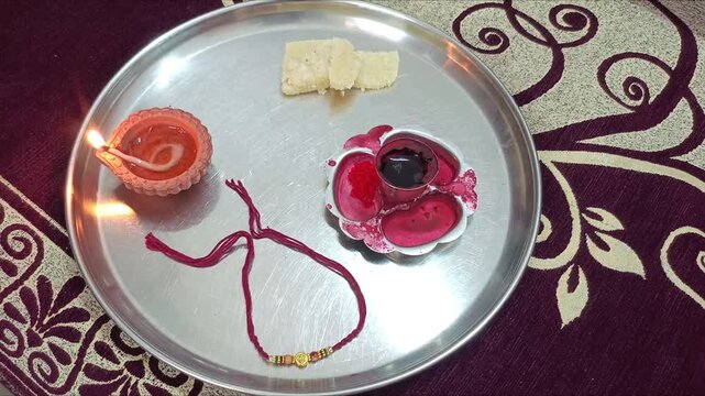 Traditional Raksha Bandhan Pooja Thali with Rakhi, Diya, Sweets, and Kumkum for Indian Festival Celebration