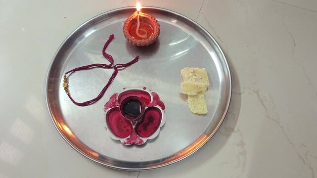 Traditional Raksha Bandhan Pooja Thali with Rakhi, Diya, Sweets, and Kumkum for Indian Festival Celebration