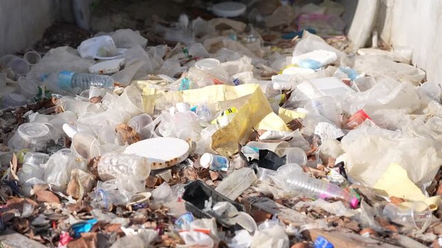 Plastic waste litter garbage pollution recycling landfill environment at dump site, disposable cup and bottle scattered on dirty debris under sunlight, ecology crisis, urgent cleanup