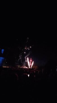 Feu d'artifice qui illumine le ciel nocturne avec des explosions &eacute;clatantes de couleurs rouges, vertes, dor&eacute;es et blanches.