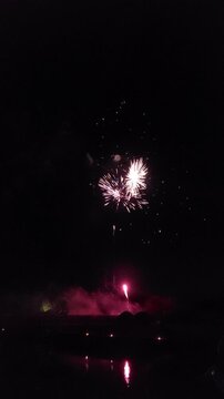 Feu d'artifice qui illumine le ciel nocturne avec des explosions &eacute;clatantes de couleurs rouges, vertes, dor&eacute;es et blanches.