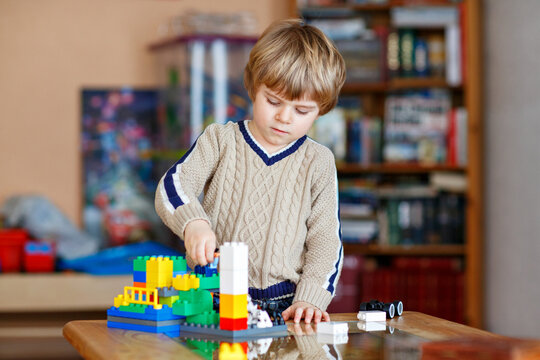 Little boy playing with colorful building blocks at home, creative child constructing toy house indoors, education and development concept. Preschool kid playing.