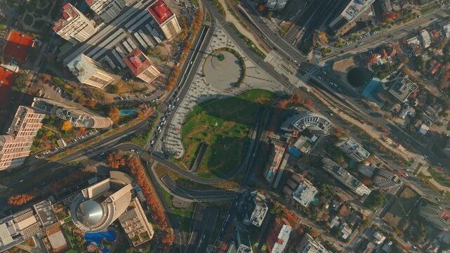 Aerial top view establishing Rene Schneider Square in Las Condes, Santiago, Chile, on a sunny day with a light mist