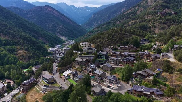 La Massana village nestled in a Pyrenean valley in Andorra, surrounded by forested mountain slopes, residential buildings and winding roads under overcast skies