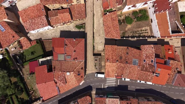 Top-down view of La Iglesuela del Cid in Maestrazgo, Teruel, Spain, showcasing terracotta rooftops, narrow streets and parked vehicles in a traditional Spanish village