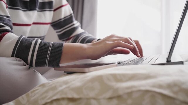Woman typing on a laptop keyboard key, conveying typing, digital communication and focused office work.