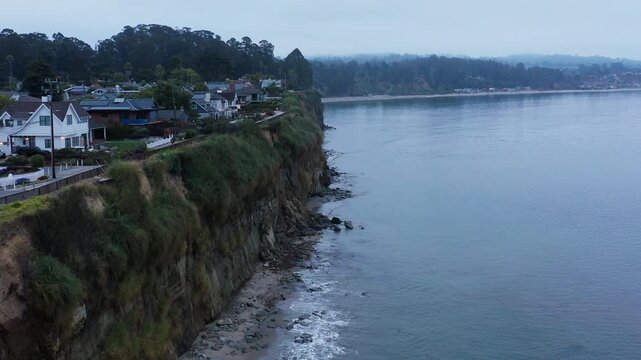 A serene early morning aerial drone shot flying along the cliffs of Capitola Village.