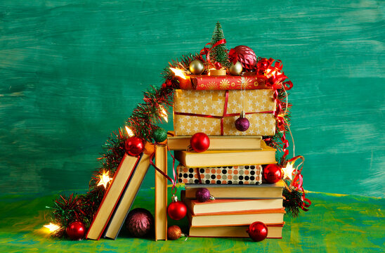 giving books for christmas,christmas  gift,present,reading,literature,education, christmas,holiday concept with heap of books, christmas lights and decoration
