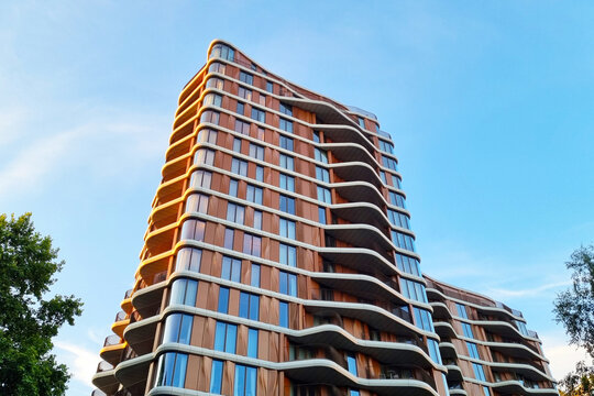 London, United Kingdom, July 10, 2026: Modern Architectural Marvel with Unique Curved Facade Against Clear Blue Sky