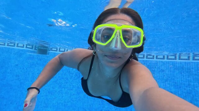Young swimmer records underwater moments with neon diving goggles