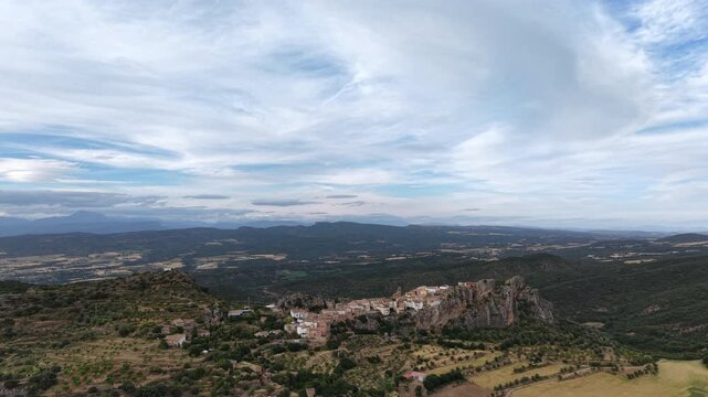 Flying towards beautiful Spanish village, built on a boulder in the mountains in the Spanish Pyrenees. Epic landscape and sky. 
