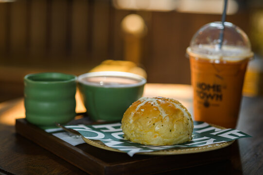 Freshly Baked Breakfast Roll with Hot Drinks and Iced Coffee on Wooden Tray