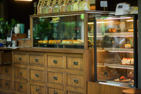 Display case and wooden counter with baked goods in a cozy pastry shop