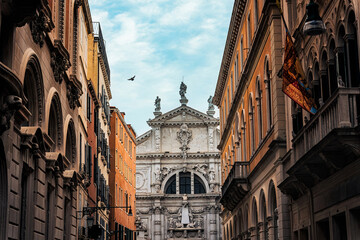 Baroque Church Facade Framed by Classic Buildings in Narrow Street in Venice Italy © Mumemories