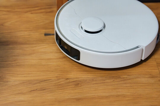 Robot Vacuum Cleaner on Hardwood Floor Smart Home Cleaning Device