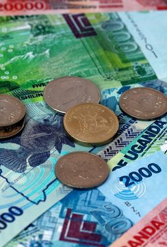 Ugandan shilling money banknotes and coins on table. Uganda cash bills of UGX currency