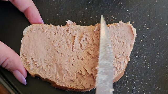 Open faced sandwiches with liver spread and fresh cucumber slices on white bread served on pink plate