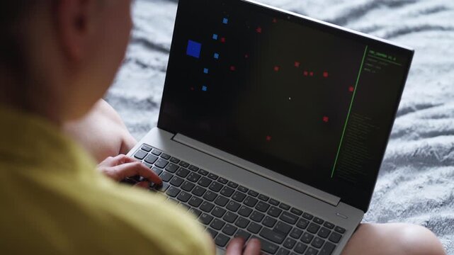 Woman playing retro arcade video game on laptop.
