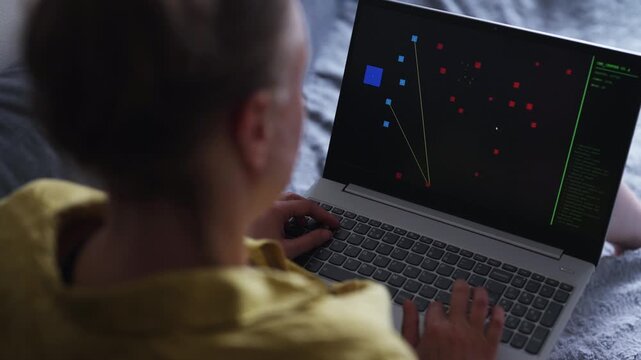 Woman playing retro arcade video game on laptop.