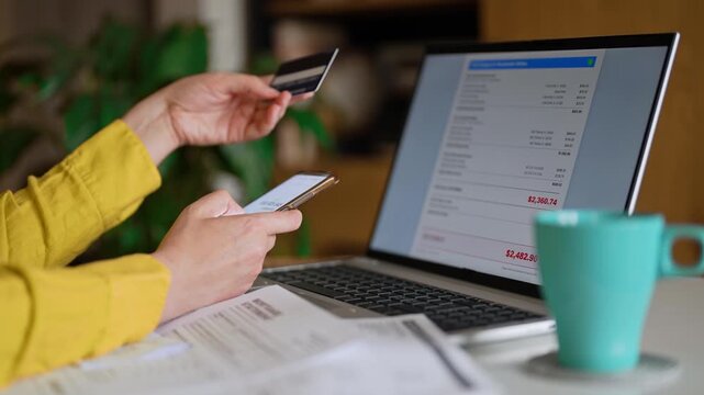 Woman calculating utility bills and household expenses on smartphone calculator.