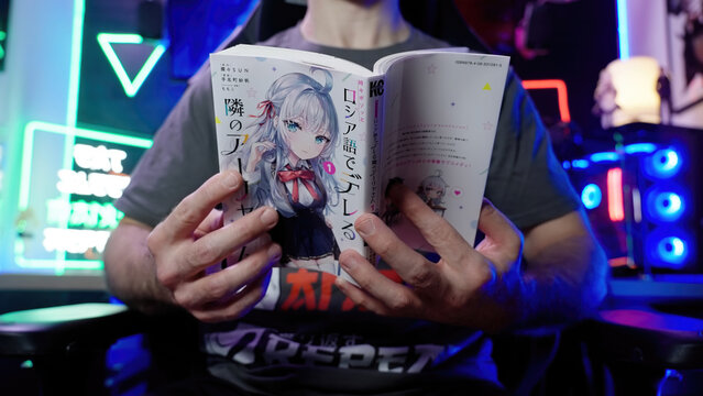 Headless person reading Japanese manga comic Roshidere in neon light gaming room