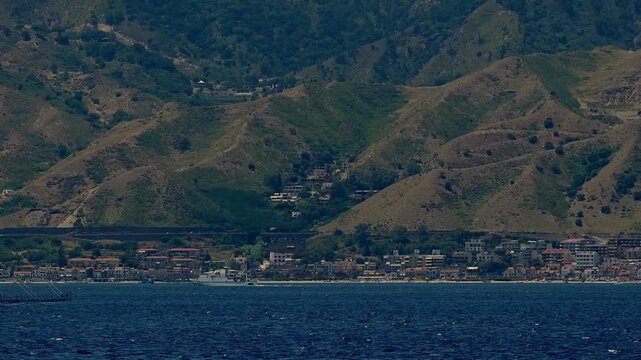 A swordfish fishing vessel passes through the Strait of Messina, Italy.