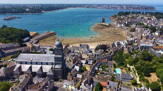 Tour Solidor overlooks Holy Cross Church, Solidor Beach, Saint-Servan, Rance Estuary and Saint-Malo Intra-Muros in Ille-et-Vilaine, Brittany, France, revealing historic waterfront, drone pullback