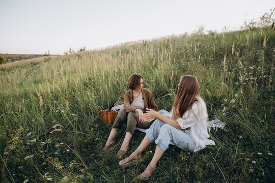 Friends talking enjoying picnic time on green hill