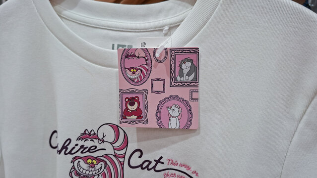 Uniqlo UT white Disney shirt with price tag featuring Cheshire Cat Lotso Marie and Lucifer character graphics on July 21, 2026 in Bangkok, Thailand.