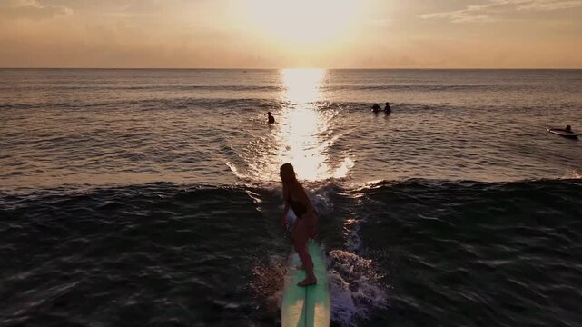 Drone aerial view of surfer at sunrise in Siargao, Philippines