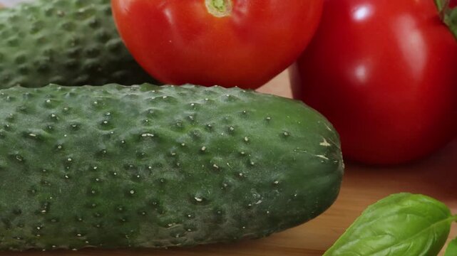 Concombres tomates basilic sur une planche en cuisine	