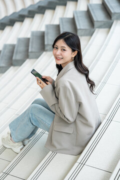Beautiful business woman using mobile phone work in business buildings. Smart female using cell phone chatting for business communication talking. Business lifestyle concept.