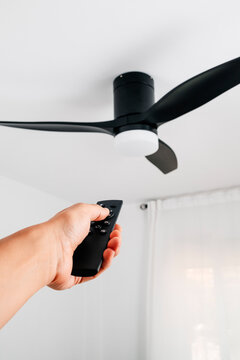 ceiling fan controlled by a man using a remote