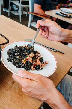 at a restaurant, a man serves himself arros negre