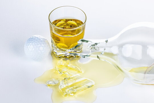 Bicchiere di Whisky con pallina da golf dopo una sconfitta a fine partita