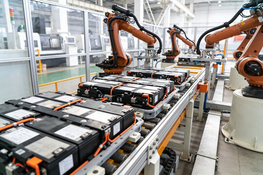 Automated robotic arms assembling battery packs on a modern factory production line