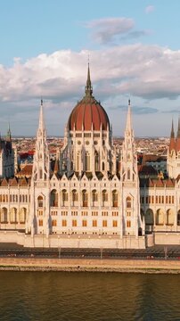 Hungarian Parliament Building aerial front view vertical format, Budapest landmark on Danube river bank sunset light, Imre Steindl neo-gothic architecture background