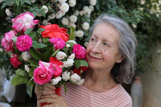 Real senior woman holding stunning flowers 