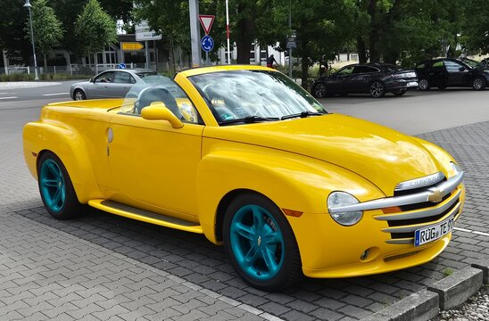 Chevrolet SSR (Super Sport Roadster) LS2 V8, Modelljahr ca. 2005&ndash;2006, Cabrio-Pick-up (Retractable Hardtop), gelb, individuell lackierte/t&uuml;rkise Felgen.