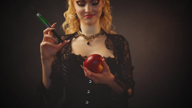 blonde woman dark queen fairytale witch character, in process of poisoning apple. Gothic fantasy evil girl smiling face holding syringe with green poison. enchanted red apple for princess. night room.