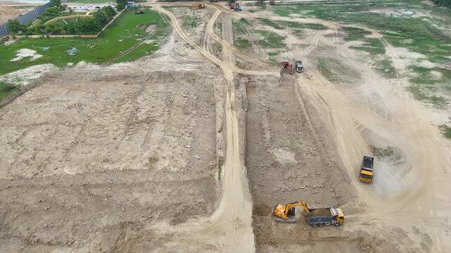 Aerial video of a land with excavation machines digging soil and showing construction