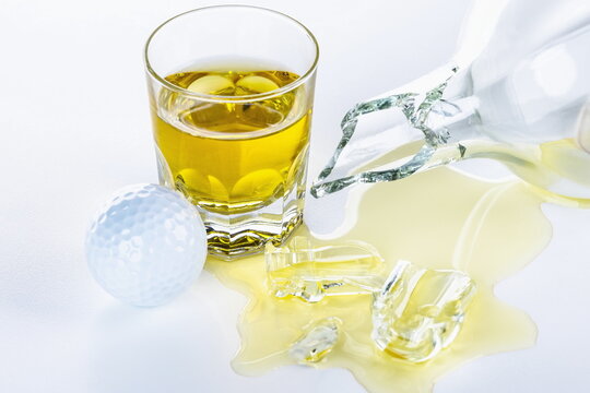 Bicchiere di Whisky con pallina da golf dopo una sconfitta a fine partita