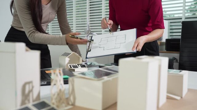 Engineering team collaborates on blueprint and project planning. Strategic partnership and innovation drive successful model development in a corporate office.