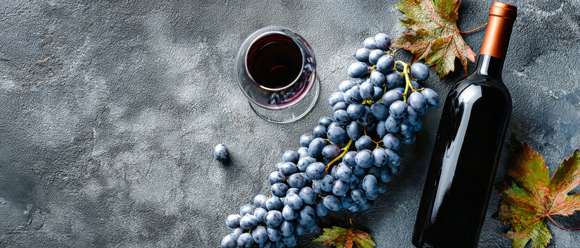 Wine bottle rests beside a glass filled with red wine and a bunc