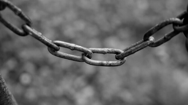 Super close-up of the metal chain on which the gate is closed. Shooting in black and white