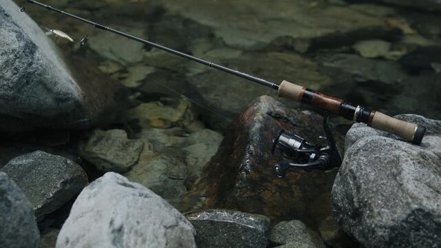 High-end JDM trout fishing tackle set against a beautiful mountain stream in Japan, 4K.