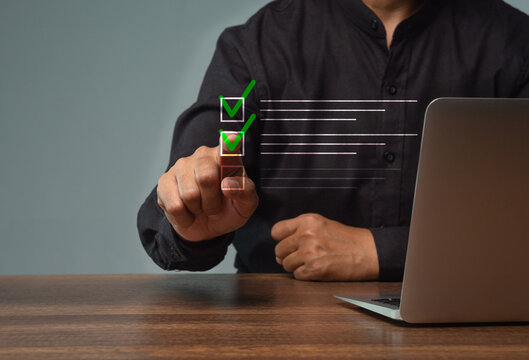 Person completing digital checklist beside laptop*