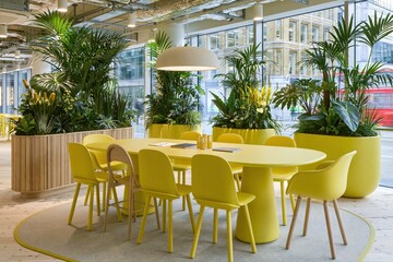 Obraz premium Modern Office Meeting Room with Yellow Furniture and Lush Green Plants