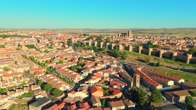 Rooftops crowd together in an old district of Avila, Spain, seen from a low aerial flyby.